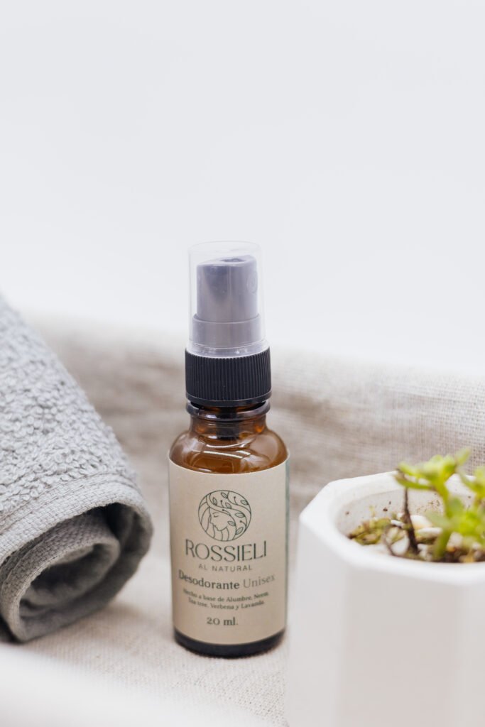 Desodorante Original de Rossieli Al Natural, presentación 20 ml, junto a una toalla y una suculenta